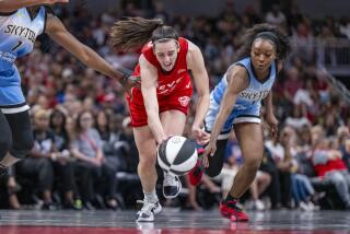Indiana Fever guard Caitlin Clark works to regain control of the ball while being defended by Chicago Sky guard Dana Evans
