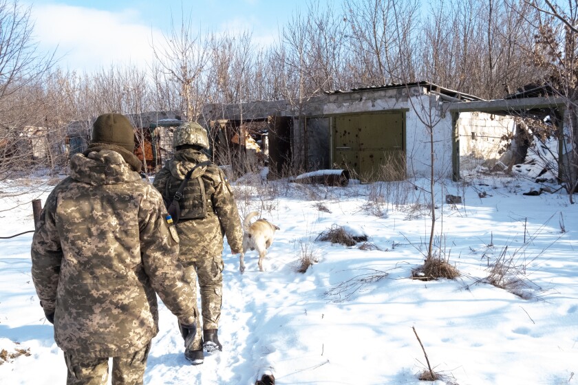 Ukrainian soldiers walk through the destroyed village of Pisky.