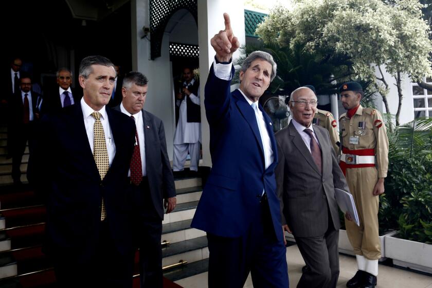 U.S. Secretary of State John F. Kerry leaves a press conference with his Pakistani counterpart Sartaj Aziz, right, in Islamabad, Pakistan.