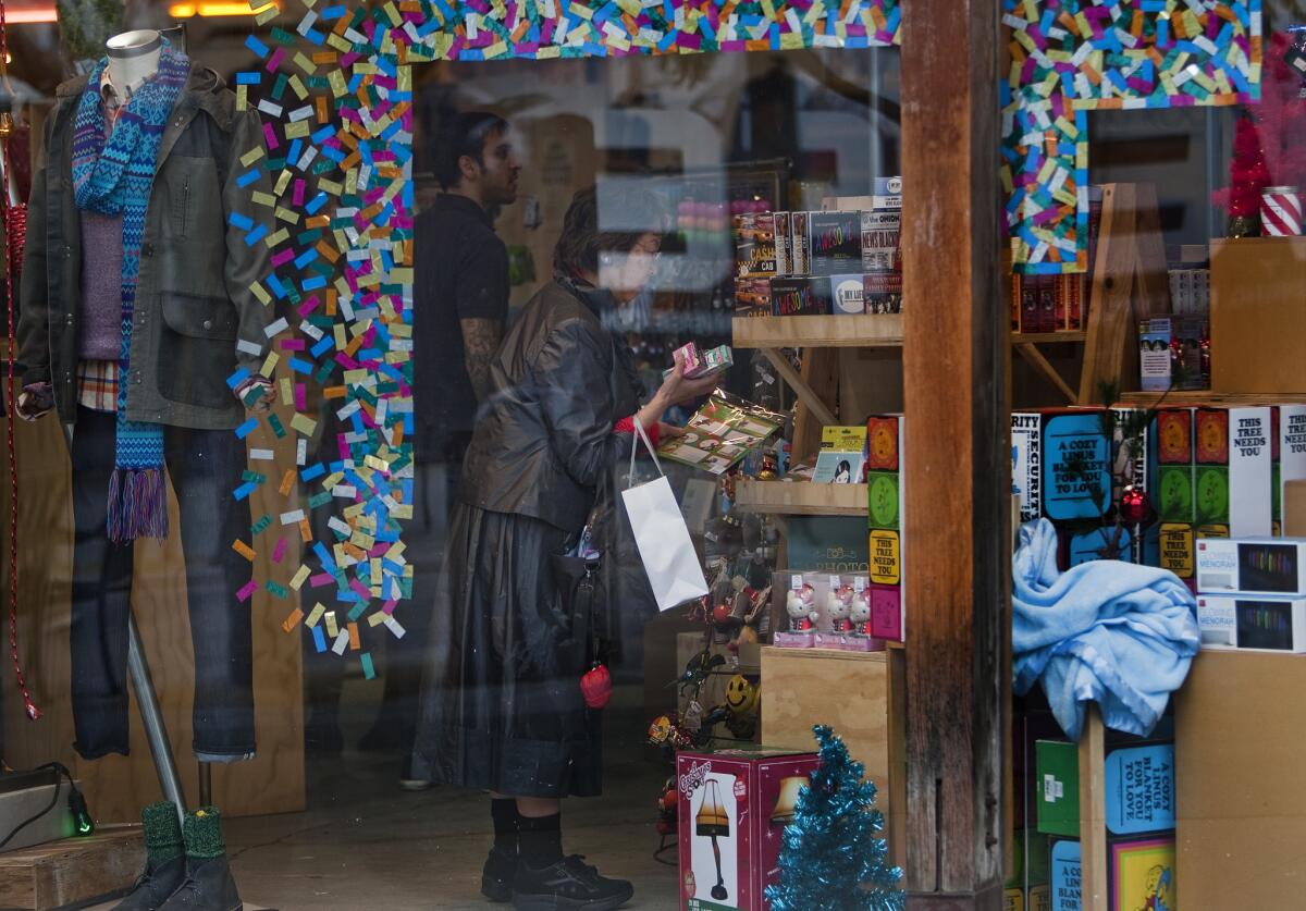 A woman browses Christmas labels while shopping at the 3rd Street Promenade.