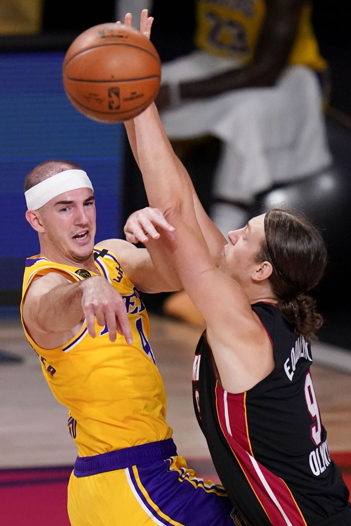 Lakers guard Alex Caruso passes around Heat center Kelly Olynyk during the first half in Game 4.