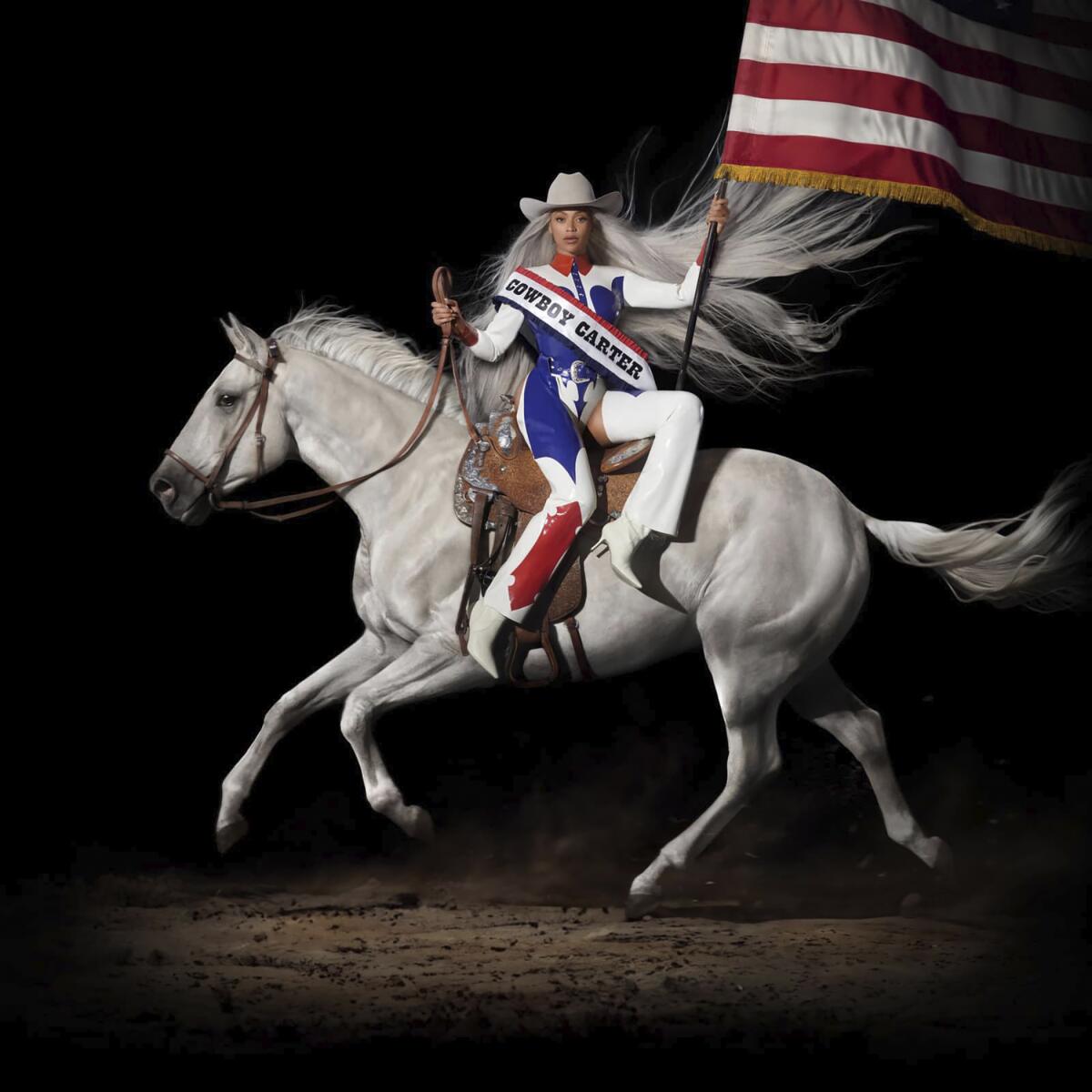 Beyoncé in red-white-and-blue rodeo garb riding a horse sidesaddle and holding an American flag for 'Cowboy Carter' album art