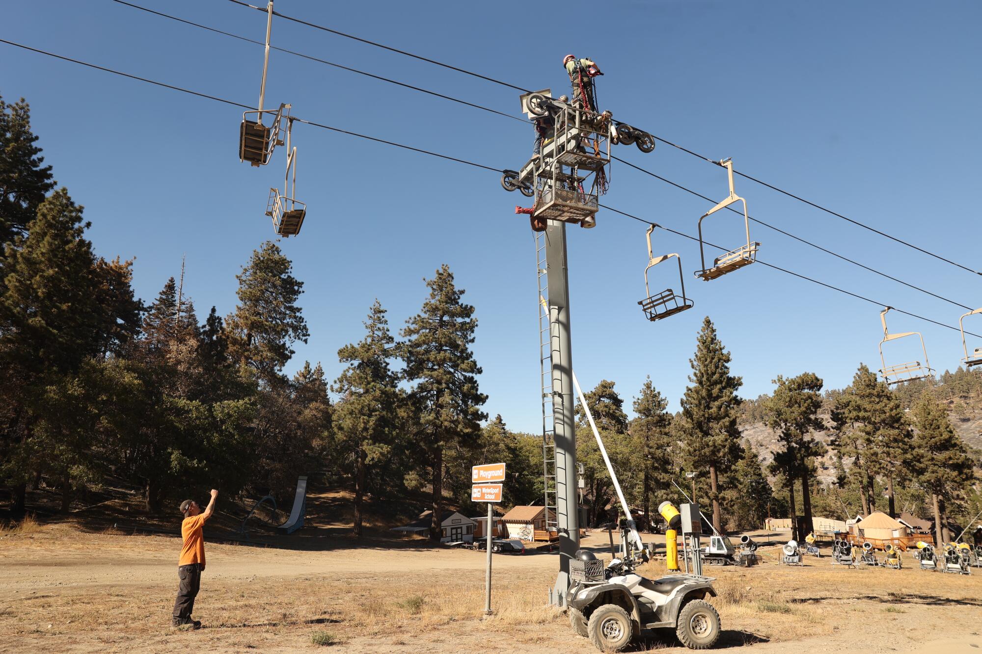 Dylan looks up as ski resort workers Justin Gaylord and Derrick Cordov work on steel wire for the chairlifts.