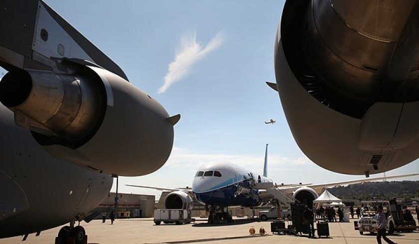 Boeing's 787 Dreamliner is framed between two large engines of a C-17 cargo plane on the tarmac at Boeing's plant in Long Beach. The aircraft maker has taken 870 orders for the Dreamliner, making it one of the biggest-selling planes ever built. See full story
