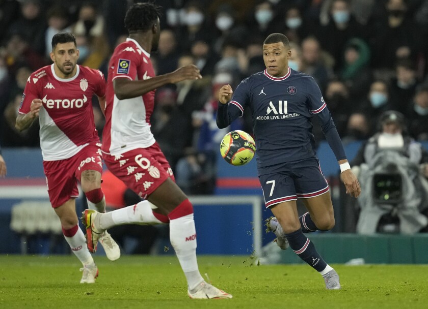 PSG's Kylian Mbappe, right, Monaco's Axel Disasi, centre, in action during the French League One soccer match between Paris Saint-Germain and Monaco at the Parc des Princes stadium in Paris, France, Sunday, Dec. 12, 2021. (AP Photo/Christophe Ena)
