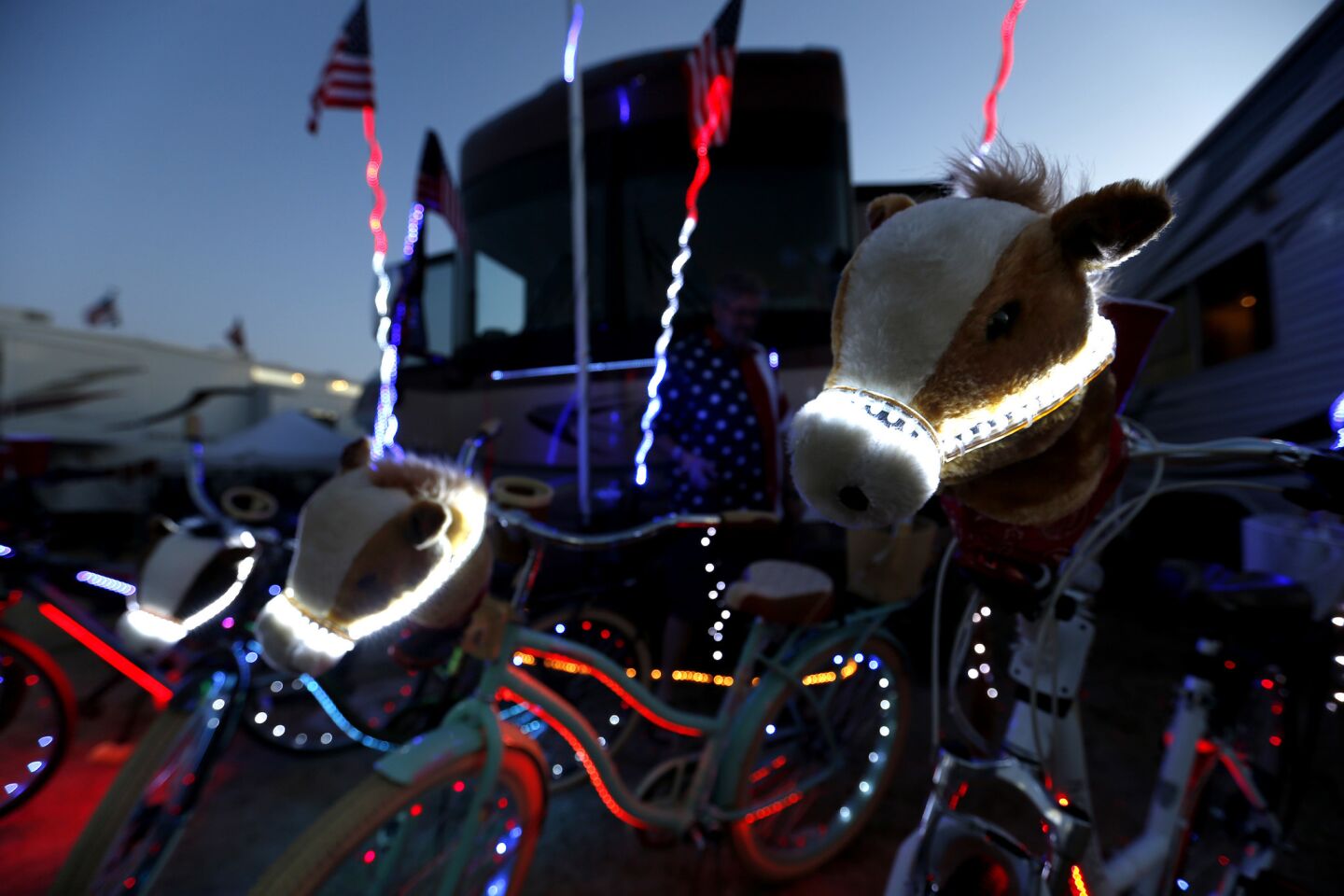 Horse heads and bicycles are illuminated with LED lights, put on by Vito Pace, of Calabasas, at dusk in the RV Resort at Stagecoach Country Music Festival in Indio.