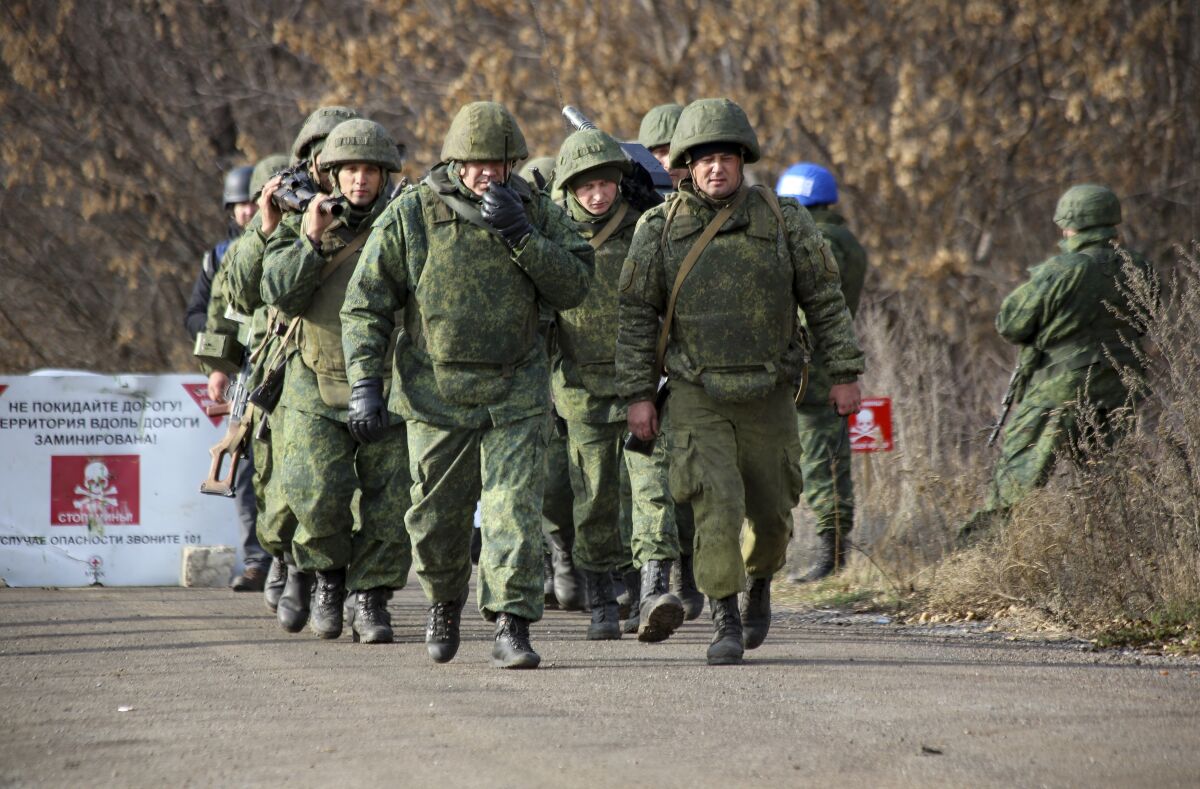 Russia-backed separatist rebels' unit walk to take their position at the new line of contact outside Petrivske, Ukraine, Saturday, Nov. 9, 2019. The Saturday pullback in the Petrivske area follows two similar movements in eastern Ukraine, where Russia-backed rebels and Ukrainian forces have been fighting since 2014. The pullbacks are seen as a significant step that could lead to a summit of Russia, Ukraine, France and Germany on ending the conflict. (AP Photo/Alexei Alexandrov)