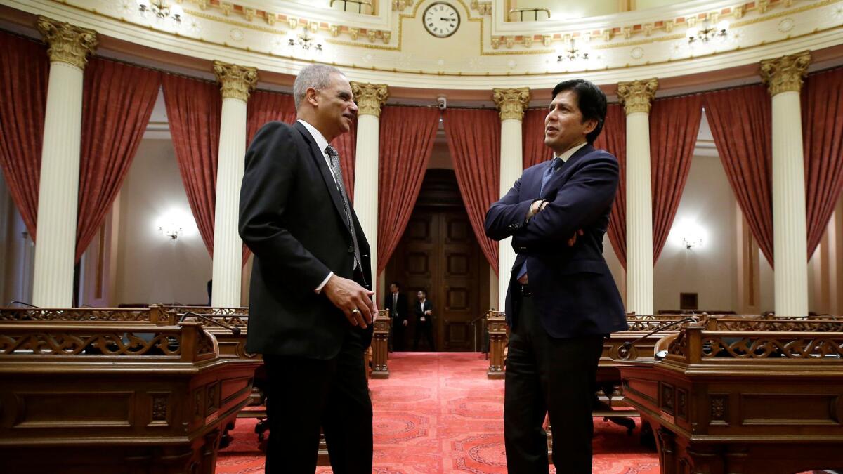 Former U.S. Attorney General Eric Holder, left, is given a tour of the state Senate chamber in Sacramento by Senate President Pro Tem Kevin de León, D-Los Angeles, on Feb. 7.