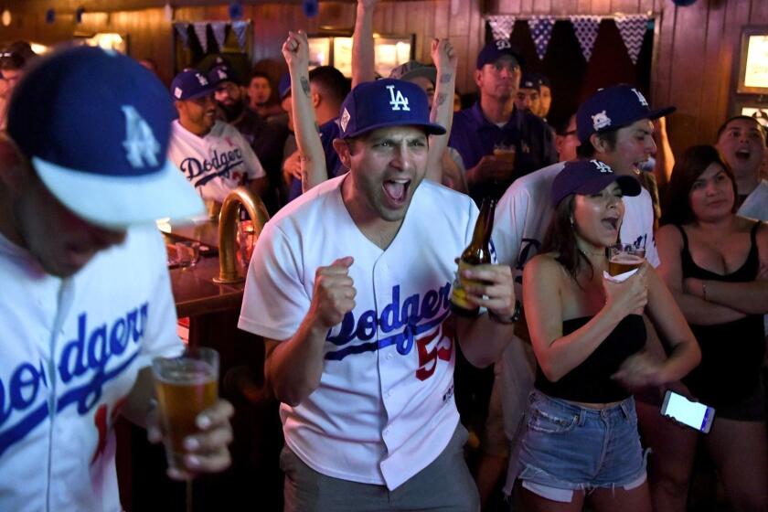 LOS ANGELES, CA - OCTOBER 25, 2017: Andrew Vialpando, center, cheers with Dodger fans while watching the World Series at the Short Stop in Echo Park. (Michael Owen Baker / For The Times)