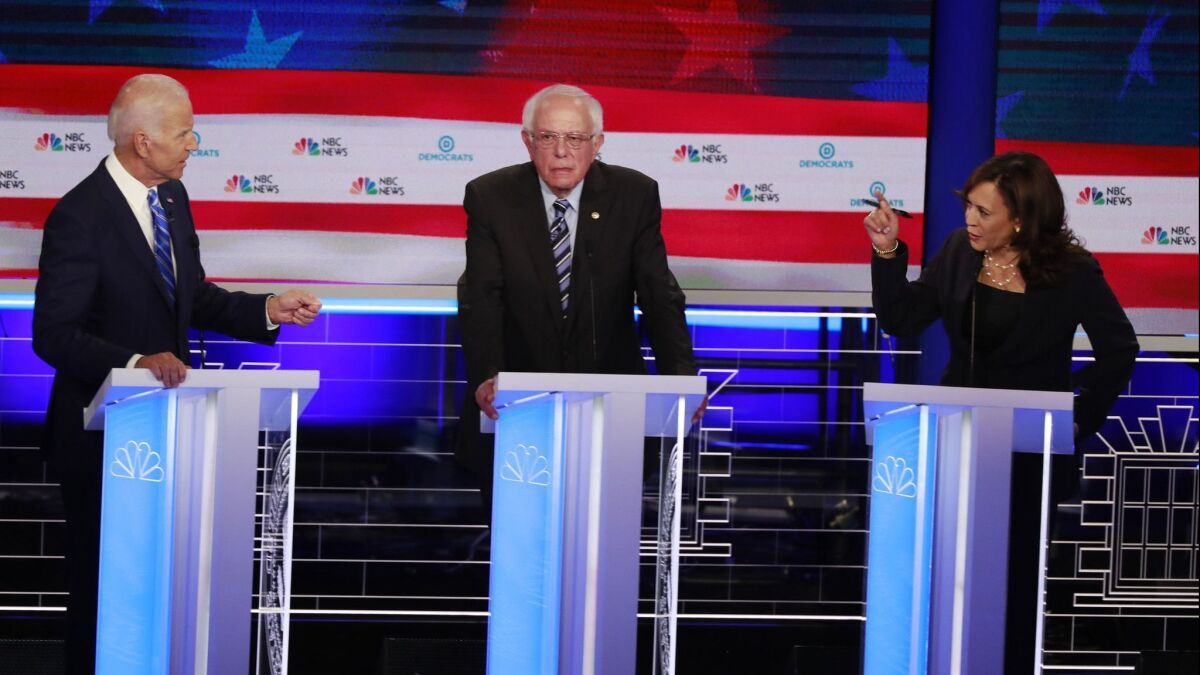 Former Vice President Joe Biden and Sen. Kamala Harris of California spar during the Democratic primary debate in June in Miami as Sen. Bernie Sanders of Vermont looks on. Harris gained ground among voters who watched the encounter.