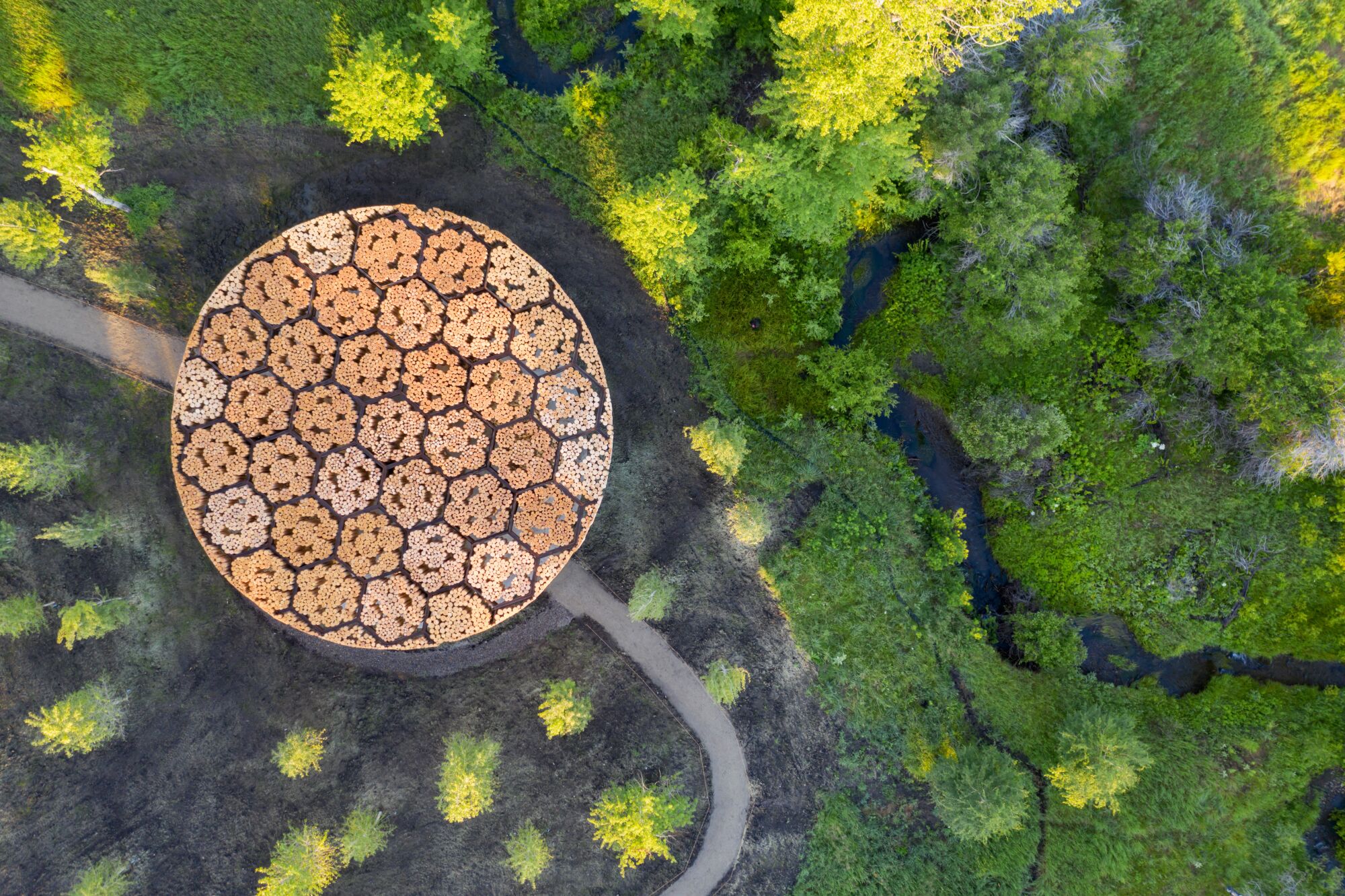 An overhead view shows a circular wood roof containing a geometric pattern of circles within it.