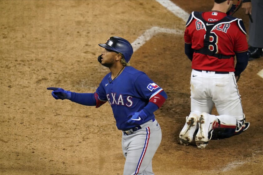 Texas Rangers' Willie Calhoun scores on a solo home run in the ninth inning of a baseball game, Tuesday, May 4, 2021, in Minneapolis. (AP Photo/Jim Mone)