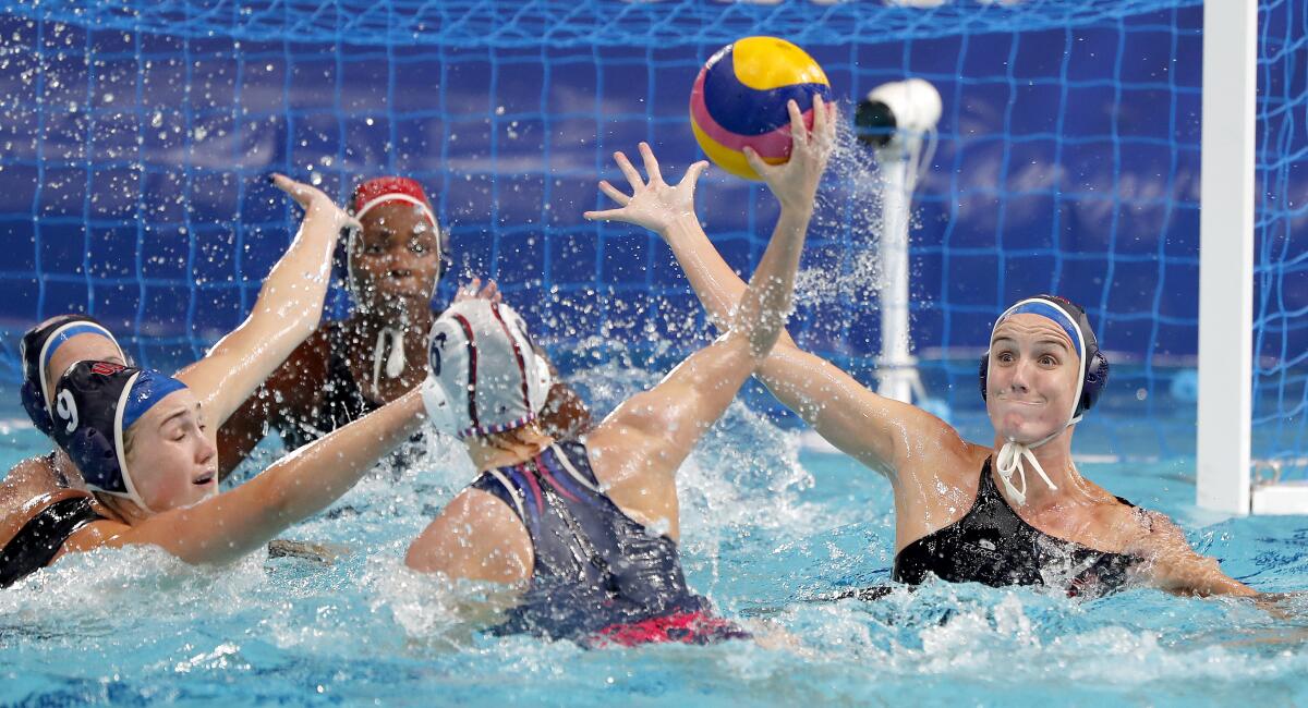 Aria Fischer tries to block a shot by ROC's Anastasia Fedotova during water polo at the Tokyo Olympics.