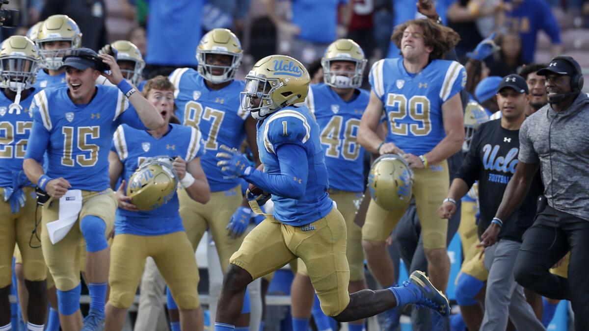 UCLA's Darnay Holmes returns a Stanford kickoff for a touchdown in the third quarter.