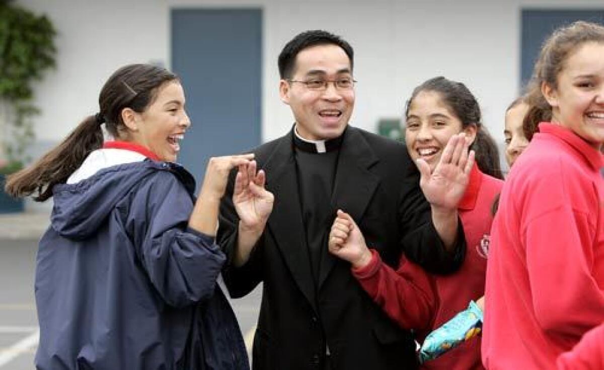 Bich Vu greets students on the campus of Holy Family Cathedral School. On Saturday, Vu will be one of three men ordained as priests in the Roman Catholic Diocese of Orange by Bishop Tod D. Brown.