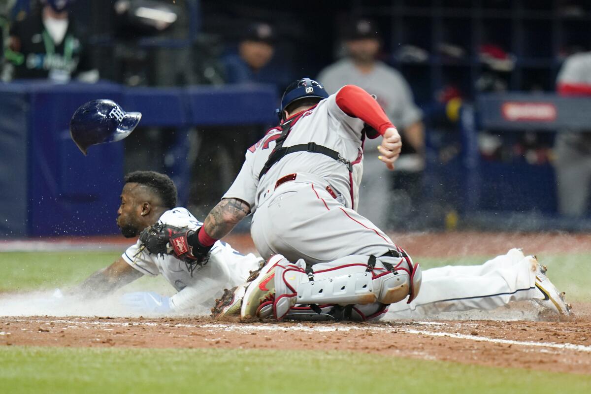 Tampa Bay Rays' Randy Arozarena steals home in the seventh inning past Boston Red Sox catcher Christian Vazquez in Game 1 of a baseball American League Division Series, Thursday, Oct. 7, 2021, in St. Petersburg, Fla. (AP Photo/Chris O'Meara)