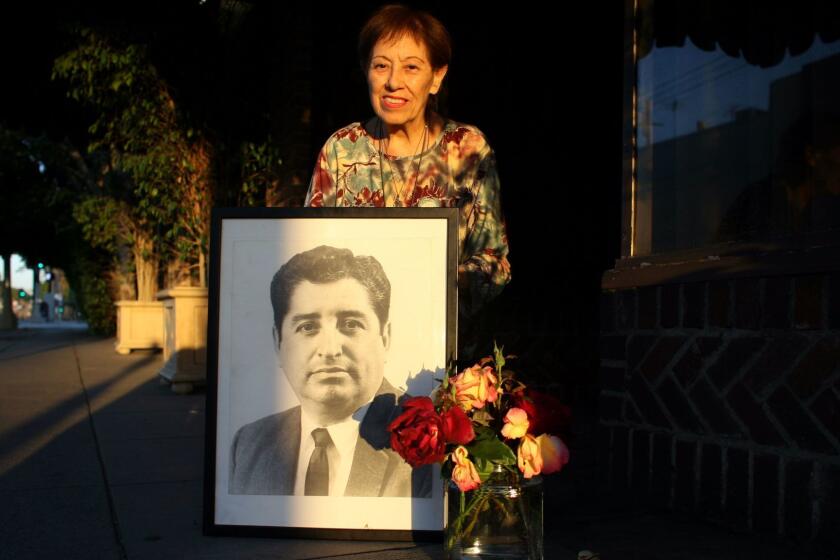 Davidson, Barbara   136280.ME.0414.SalazarOn the day LA Times columnist Ruben Salazar was killed by a sheriff s deputy, Frank Casado scrawled the trailblazing newsman s name and the date of his death in a block of wet cement on the sidewalk in front of his restaurant, El Adobe Cafe. Lucy Casado, Frank's widow, kneels on the sidewalk in front of the marker that reads: Ruben Salazar. 8291970 and holds a photo of Ruben.