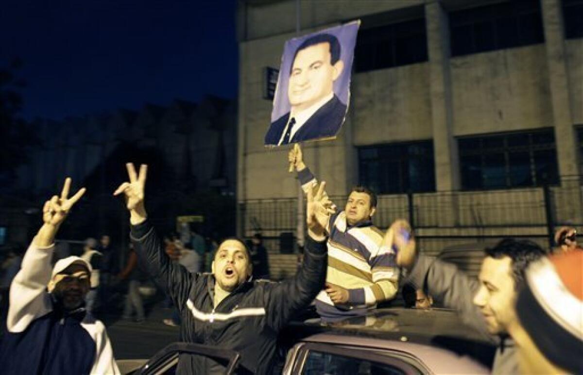A group of pro-government supporters take to the streets holding a poster of Egyptian President Hosni Mubarak after his speech, in the Imbaba neighborhood of Cairo, Egypt, Wednesday, Feb. 2, 2011. After Mubarak announced Tuesday he would not run for a new term in September elections but rejected protesters' demands he step down immediately and leave the country, clashes erupted between protesters and government supporters in the Mediterranean city of Alexandria and gunshots were heard, according to footage by Al-Jazeera television. (AP Photo/Ben Curtis)