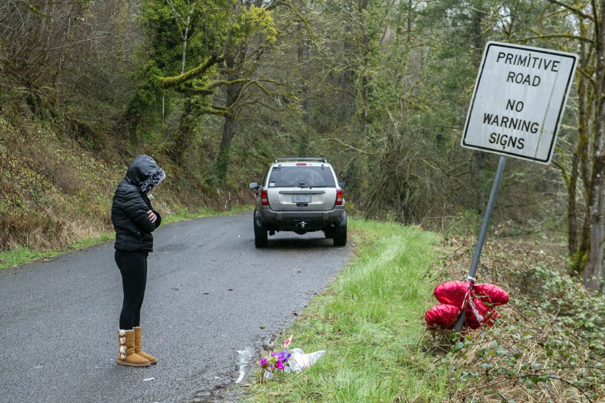 FILE - Brandy Pickard of Washougal, Wash., pauses to honor the memory of Meshay "Karmen" Melendez, 27, and her daughter, Layla Stewart, 7, along Wooding Road in Washougal, Wash., Thursday, May 23, 2023. The man named as a person of interest in the disappearance of his ex-girlfriend and her 7-year-old daughter was charged with two counts of murder in their deaths, police in Washington state said Friday, March 31, 2023. (Amanda Cowan/The Columbian via AP, File)
