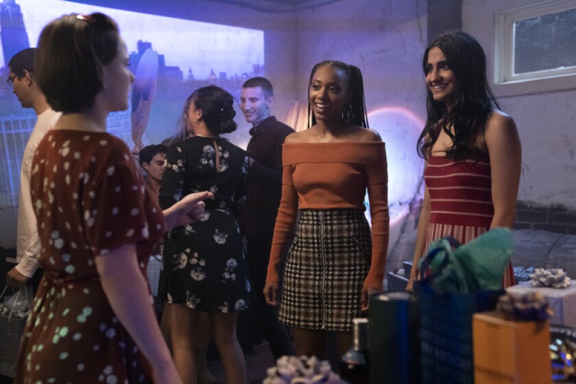 Three college students chatting at a party.