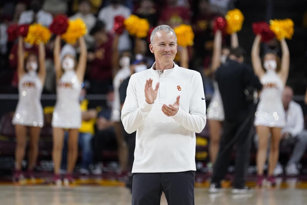 USC coach Andy Enfield smiles and claps while on the court before an NCAA college basketball game