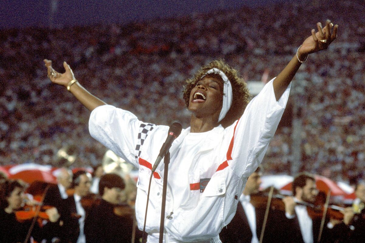 Whitney Houston, pictured singing at the Super Bowl in 1991, is among the artists due for induction in the Rock and Roll Hall of Fame, which announced it was postponing its annual ceremony.
