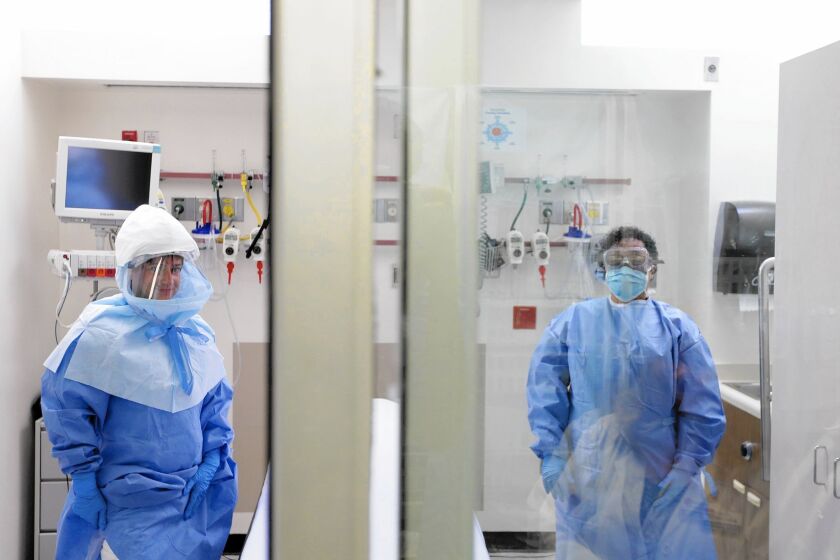 A medical worker wears a protective suit inside an isolation room appropriate to handle Ebola patients at Bellevue Hospital Center in New York.