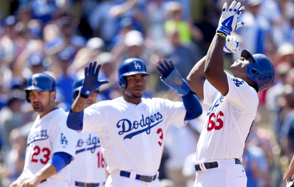 Dodgers right fielder Yasiel Puig (66) celebrates with teammates Carl Crawford (3), Adrian Gonzalez (23) and Andre Ethier (16) after hitting a three-run home run against the Diamondbacks in the sixth inning Sunday.