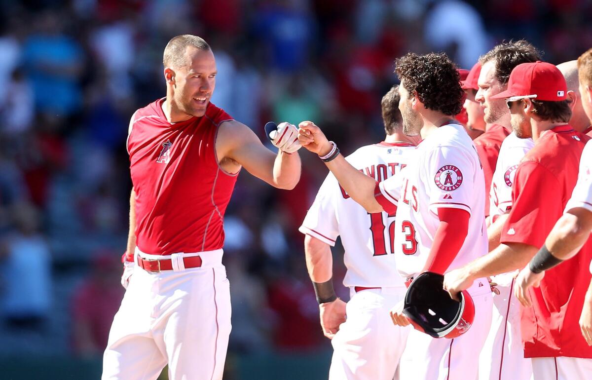 David Murphy, left, is congratulated by Angels teammate David DeJesus (3) after deliver a walk-off hit against the Orioles in the 11th inning Sunday afternoon in Anaheim.