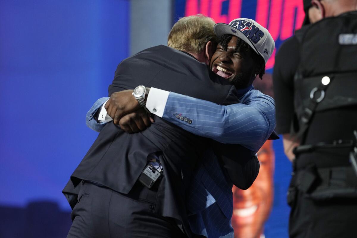 Alabama edge rusher Will Anderson Jr., right, lifts commissioner Roger Goodell off the ground with a hug.
