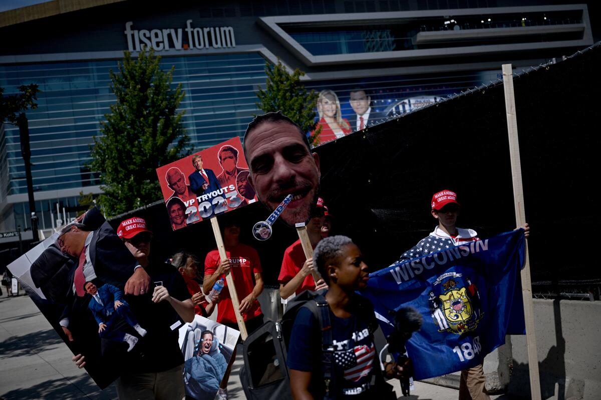 Supporters of Donald Trump hold signs outside the Fiserv Forum in Milwaukee.