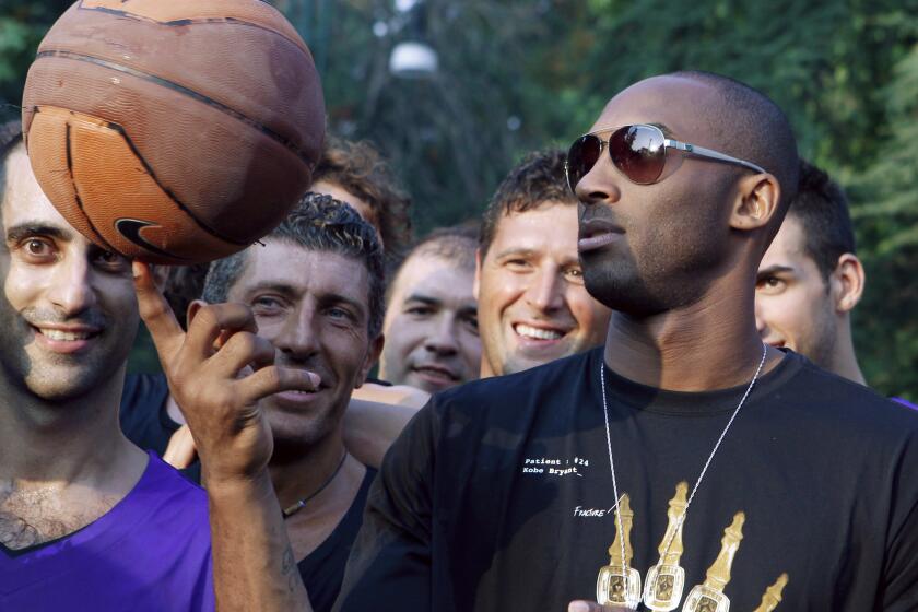U.S. basketball star Kobe Bryant plays with a ball during a sponsor's appearance in Milan, Italy, Wednesday, Sept. 28, 2011. Bryant said it's "very possible" he will play in Italy during the NBA lockout, adding the country is like home because he spent part of his childhood there. (AP Photo/Luca Bruno)