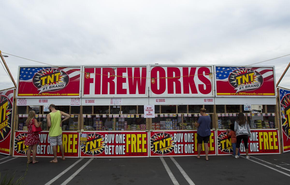 People shop at a fireworks stand on Warner Avenue benefiting Ocean View High School's cheer, baseball and robotics programs on July 1, 2015. Huntington Beach now is trying to make the process fairer for those who want to sell fireworks.