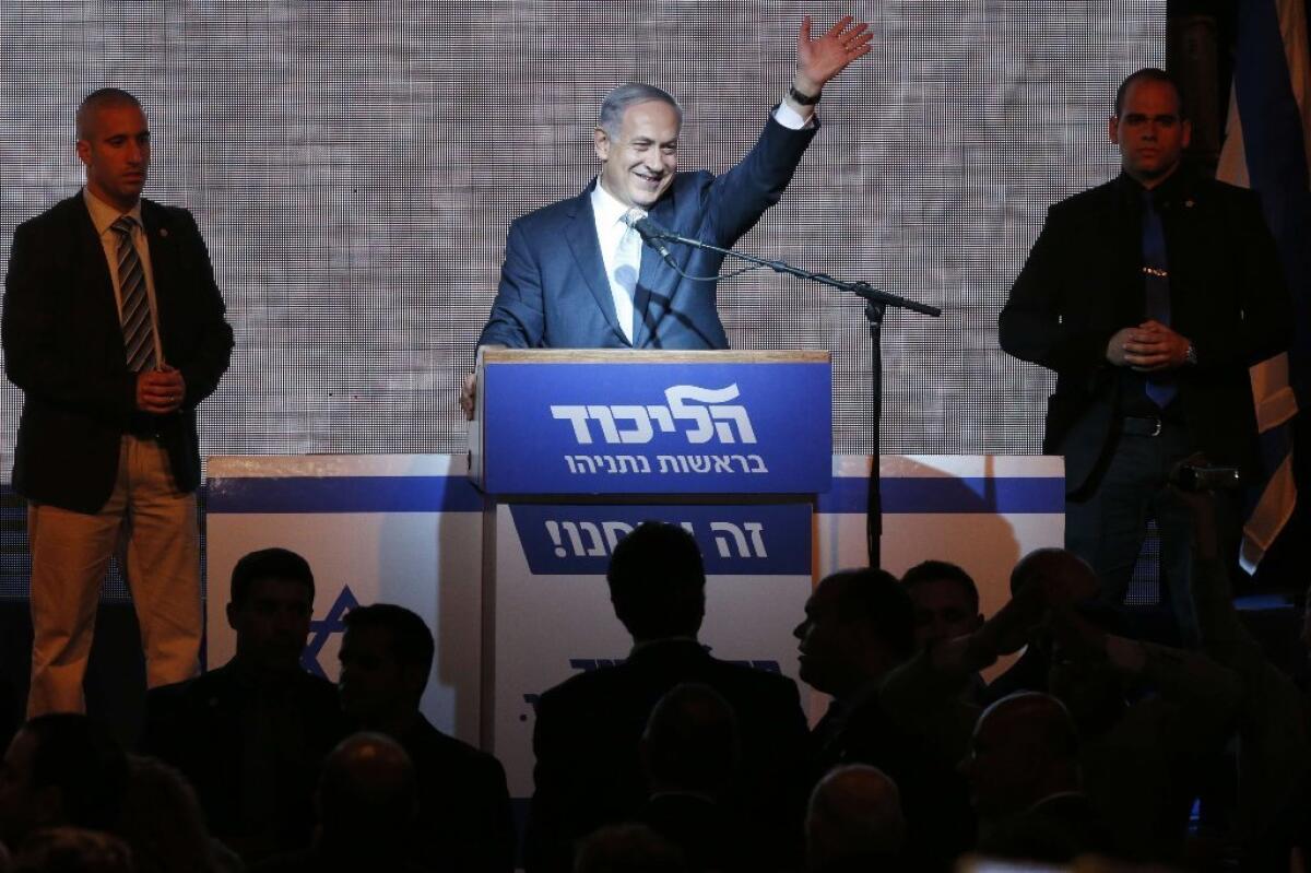 Israeli Prime Minister Benjamin Netanyahu waves from the stage as he reacts to exit poll figures in Israel's parliamentary elections.