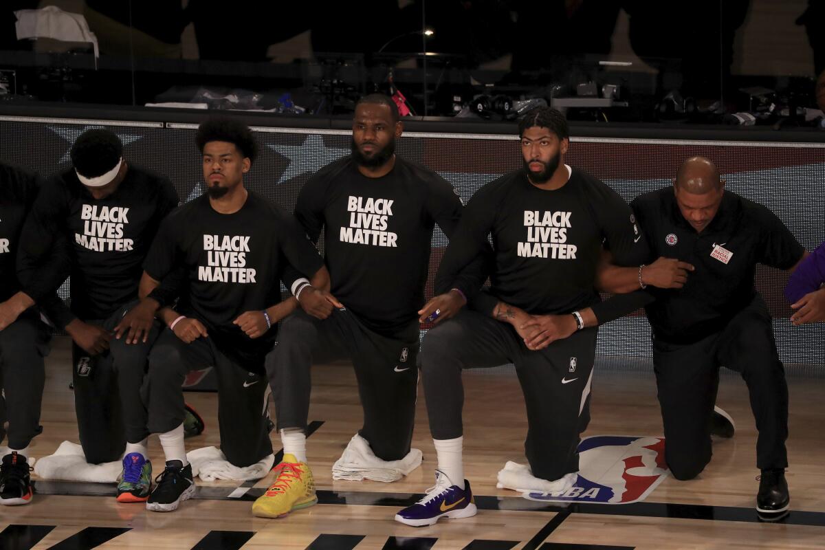 Lakers star LeBron James, third from left, and Anthony Davis, second from right, wear Black Lives Matter shirts.
