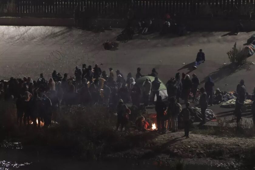 Migrantes reunidos en torno a una hoguera cerca de la frontera 