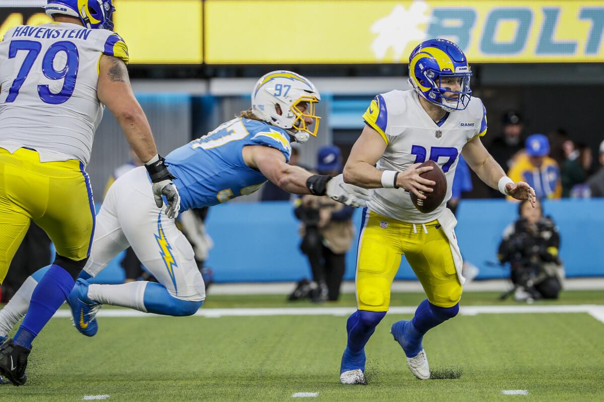 Rams quarterback Baker Mayfield (17) escapes the pressure of Chargers linebacker Joey Bosa (97).