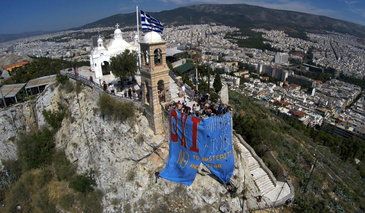 Supporters of a "no" vote in the Greek referendum on a bailout plan for country hang a banner reading in Greek and English ''NO to austerity and fear'' atop Lycabettus hill in Athens on July 2.