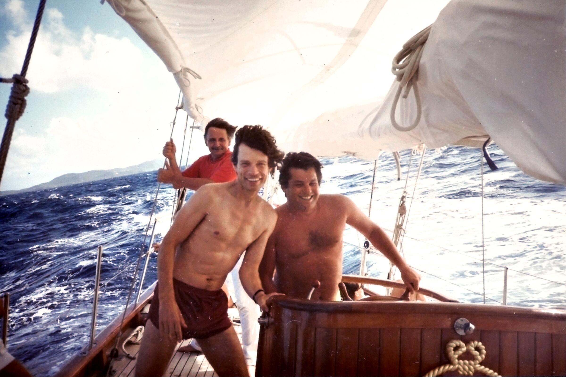Three men sailing a boat 