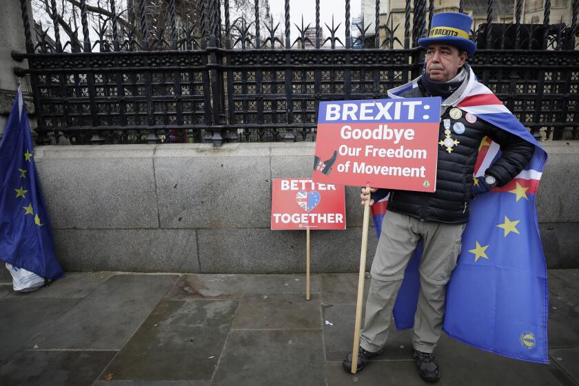 Anti-Brexit campaigner Steve Bray holds banners as he stands outside Parliament in London, Thursday, Jan. 30, 2020. Although Britain formally leaves the European Union on Jan. 31, little will change until the end of the year. Britain will still adhere to the four freedoms of the tariff-free single market – free movement of goods, services, capital and people. (AP Photo/Kirsty Wigglesworth)