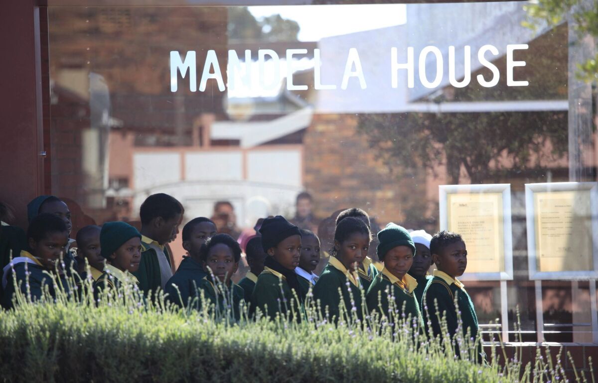 Schoolchildren line up Monday to visit the house of Nelson Mandela in the Soweto district of Johannesburg, South Africa. The 94-year-old Mandela remained in a Pretoria hospital for a sixth day after a recurrence of a longstanding lung infection.