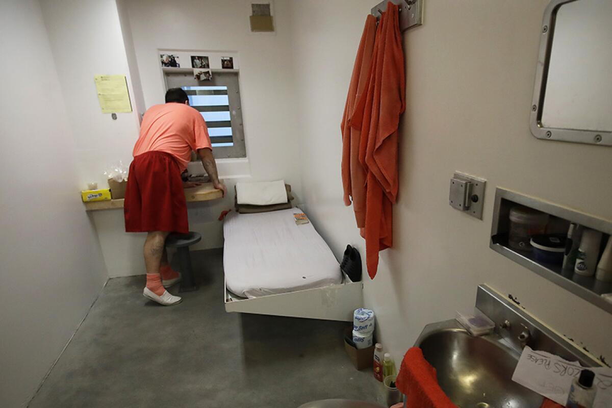 An inmate looks out a window in his solitary confinement cell