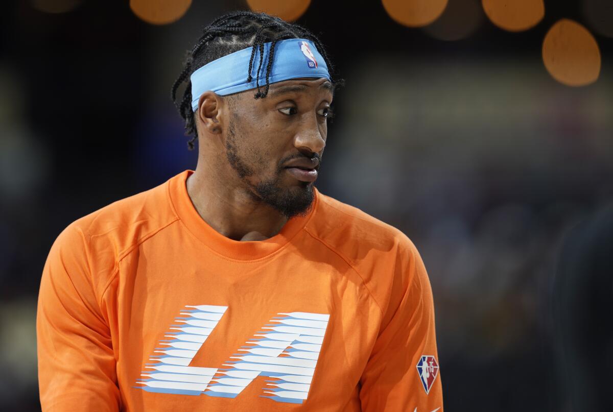 Los Angeles Clippers forward Robert Covington wears an orange Clippers warmup shirt