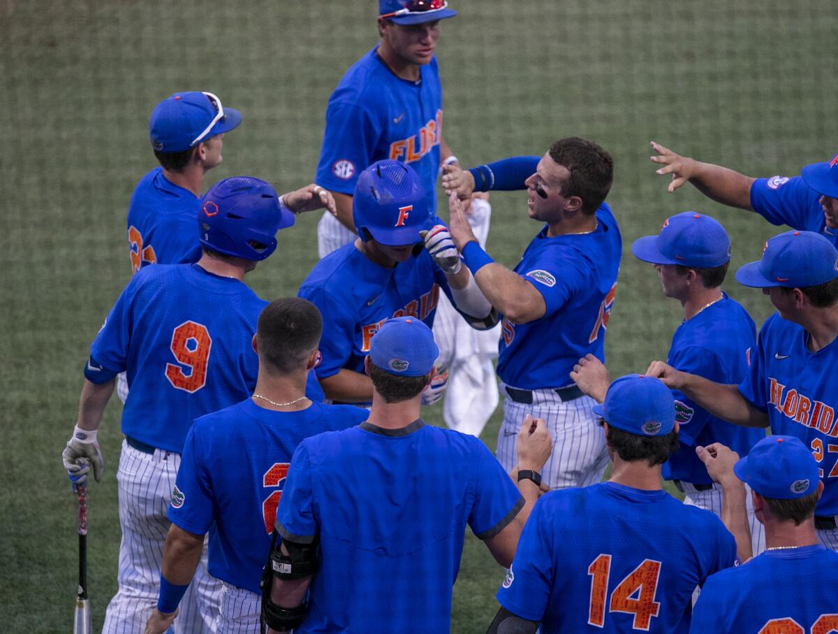Florida's Jud Fabian, second from top, celebrates with teammates after his home run against Oklahoma during an NCAA college baseball tournament regional game Sunday, June 5, 2022, in Gainesville, Fla. (Cyndi Chambers/Ocala Star-Banner via AP)
