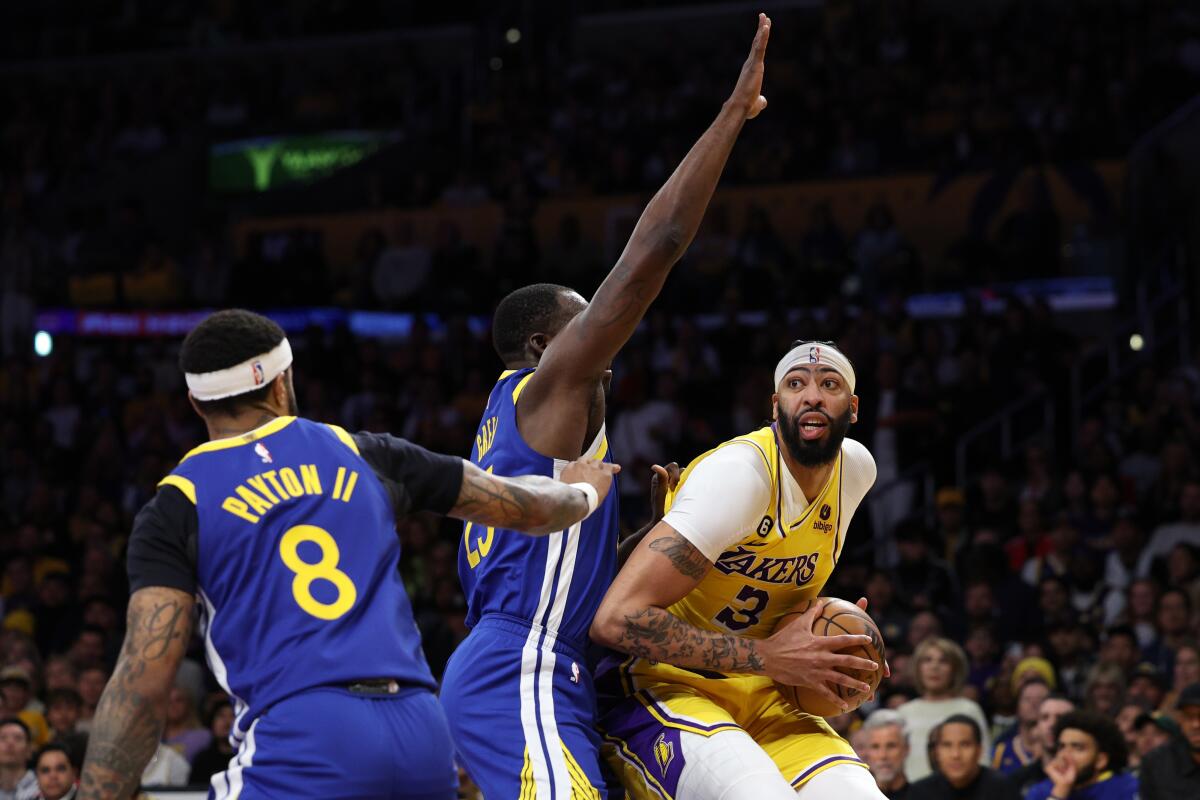 Lakers forward Anthony Davis gathers himself as he looks to score against Warriors forward Draymond Green.