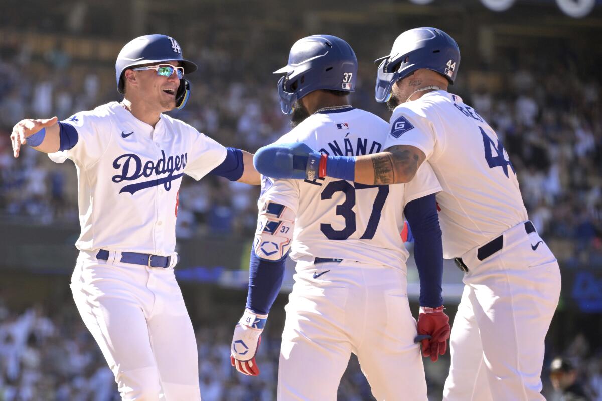 Teoscar Hernández is congratulated by Kiké Hernández, left, and Andy Pages after his walk-off single.