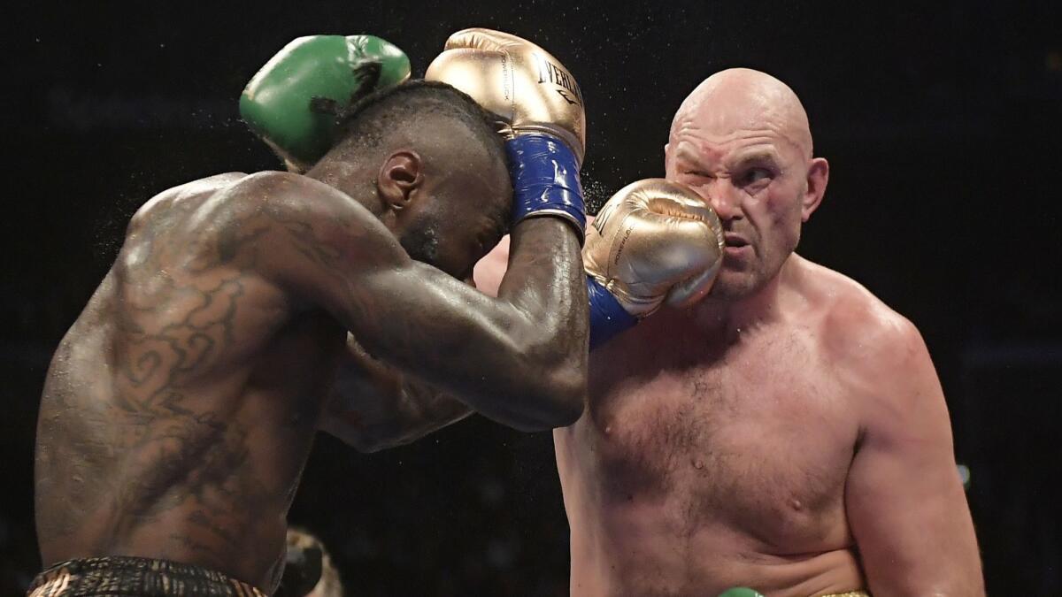 Deontay Wilder, left, connects with Tyson Fury during a WBC heavyweight championship boxing match.