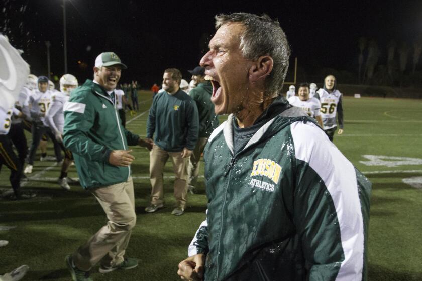Edison High Coach Dave White celebrates after getting soaked following a 44-24 win over La Mirada in the CIF Southern Section Division 3 championship game on Friday.