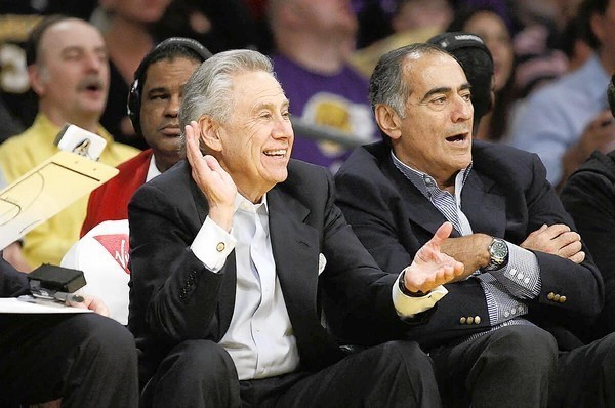 AEG chief Philip Anschutz, left, watches a Lakers-Timberwolves game at Staples Center in 2011.