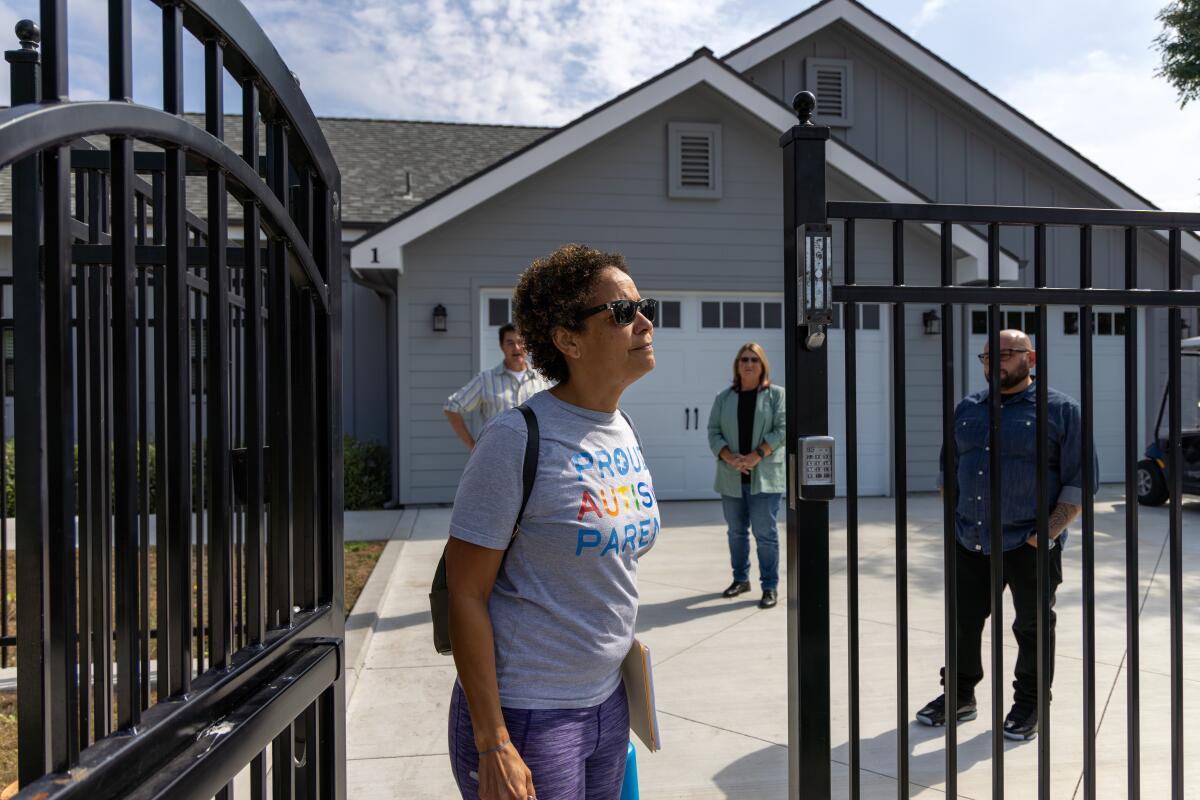 Christine LyBurtus standing at the front gate of a residential care facility